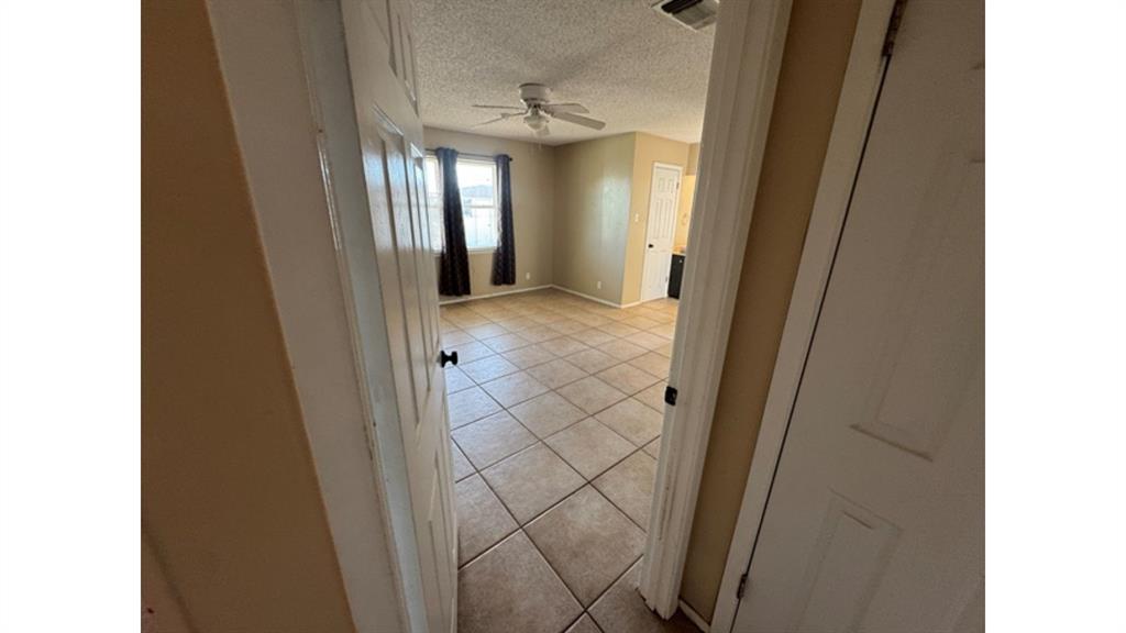 4004 Vicky Street Big Spring, TX 79720 - Photo 16 of 37 Hallway featuring a textured ceiling and light tile patterned flooring