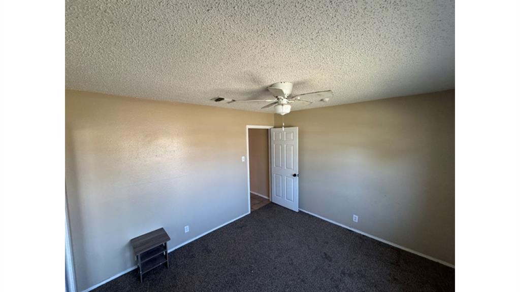4004 Vicky Street Big Spring, TX 79720 - Photo 17 of 37 Empty room featuring dark colored carpet, ceiling fan, and a textured ceiling