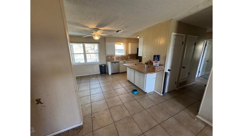 4004 Vicky Street Big Spring, TX 79720 - Photo 2 of 37 Kitchen featuring white cabinets, light countertops, a textured ceiling, light tile patterned floors, and a ceiling fan