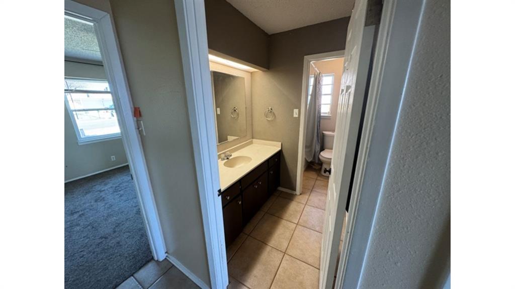4004 Vicky Street Big Spring, TX 79720 - Photo 22 of 37 Bathroom featuring vanity, light carpet, and light tile patterned floors