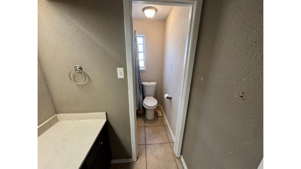 4004 Vicky Street Big Spring, TX 79720 - Photo 23 of 37 Bathroom featuring light tile patterned floors, vanity, and a textured wall
