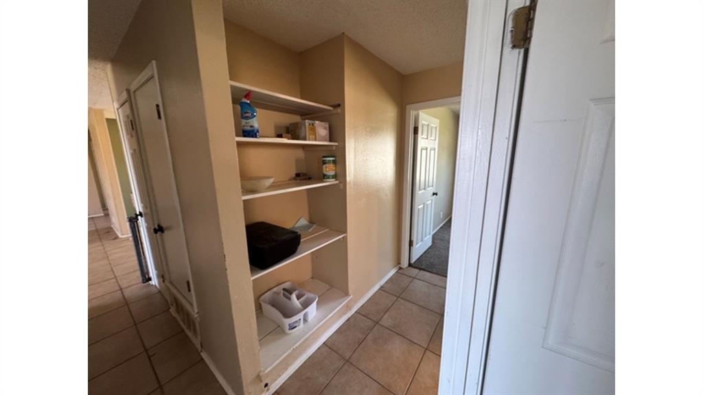 4004 Vicky Street Big Spring, TX 79720 - Photo 24 of 37 Hall featuring a textured ceiling and light tile patterned flooring