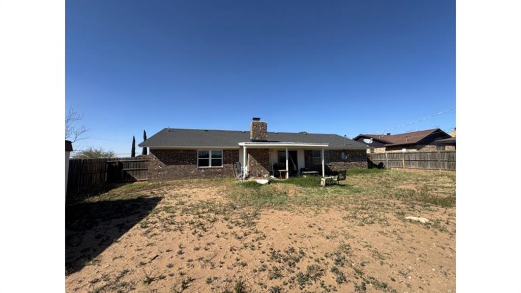 4004 Vicky Street Big Spring, TX 79720 - Photo 36 of 37 Back of property featuring a patio, a chimney, a fenced backyard, and brick siding