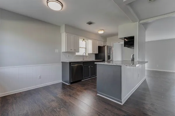 a kitchen with a sink cabinets and wooden floor