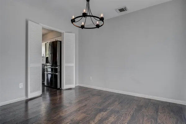 a view of a storage & utility room with wooden floor and cabinets