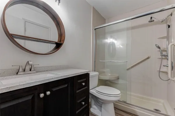 a bathroom with a granite countertop toilet sink and mirror