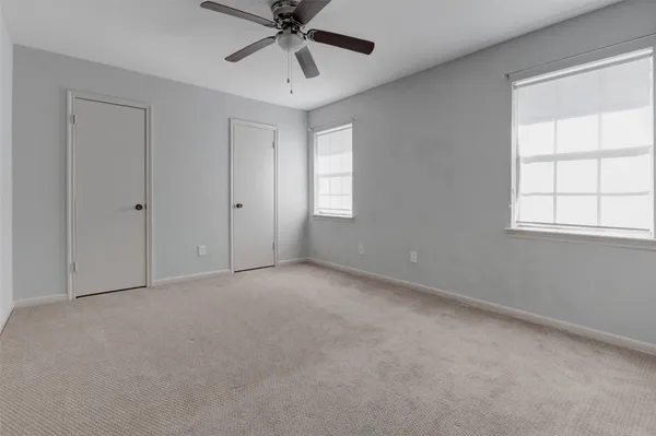 an empty room with a window and a fan