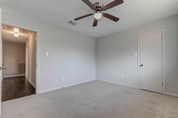 an empty room with closet and a chandelier fan