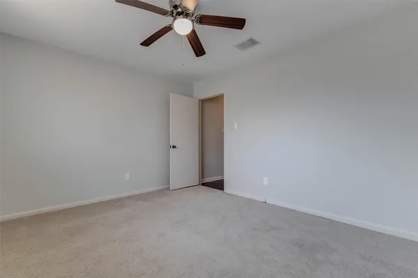 an empty room with a fan and a fan