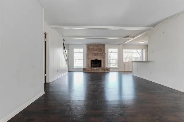 an empty room with wooden floor and fireplace