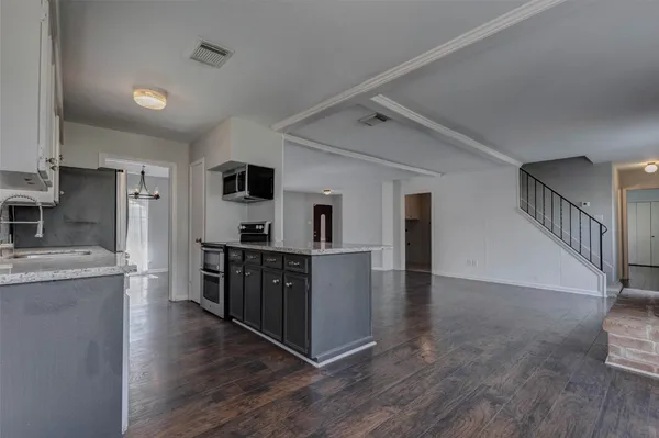 a large kitchen with a stove and cabinets