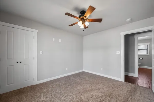 a view of room with ceiling fan and windows