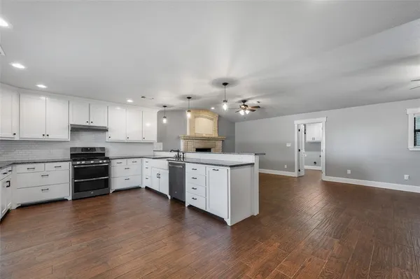 a large kitchen with cabinets wooden floor and stainless steel appliances