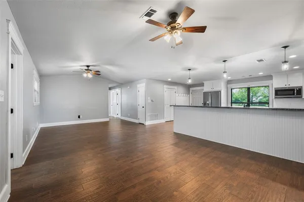 a view of an empty room with a fireplace and a chandelier
