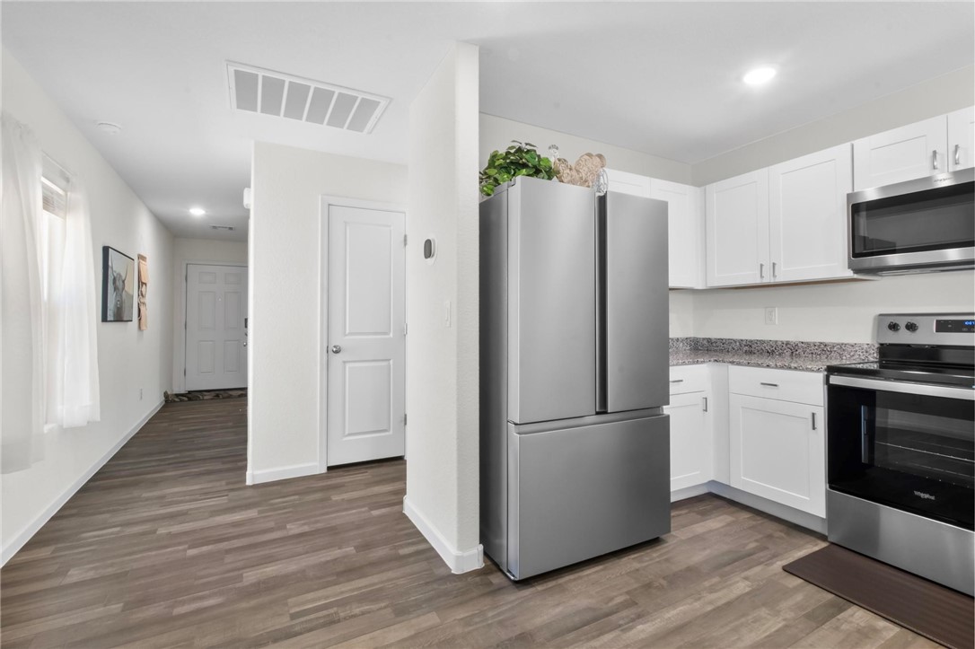 2424 Granite Road Bullhead City, AZ 86442 - Photo 11 of 50 Kitchen area featuring white cabinetry, a stainless steel refrigerator, and a stainless steel oven/range with an overhead microwave