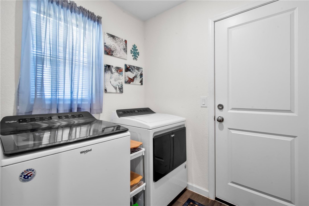 2424 Granite Road Bullhead City, AZ 86442 - Photo 12 of 50 Dedicated laundry area featuring a window with blinds, white paneled door with brushed nickel hardware, and wood-finish flooring
