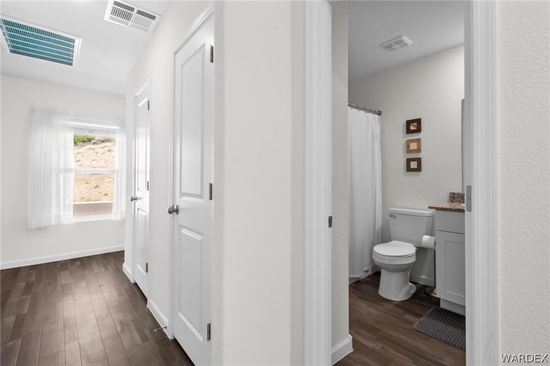 2424 Granite Road Bullhead City, AZ 86442 - Photo 19 of 50 Hallway with wood-finish flooring, white paneled doors, and a window