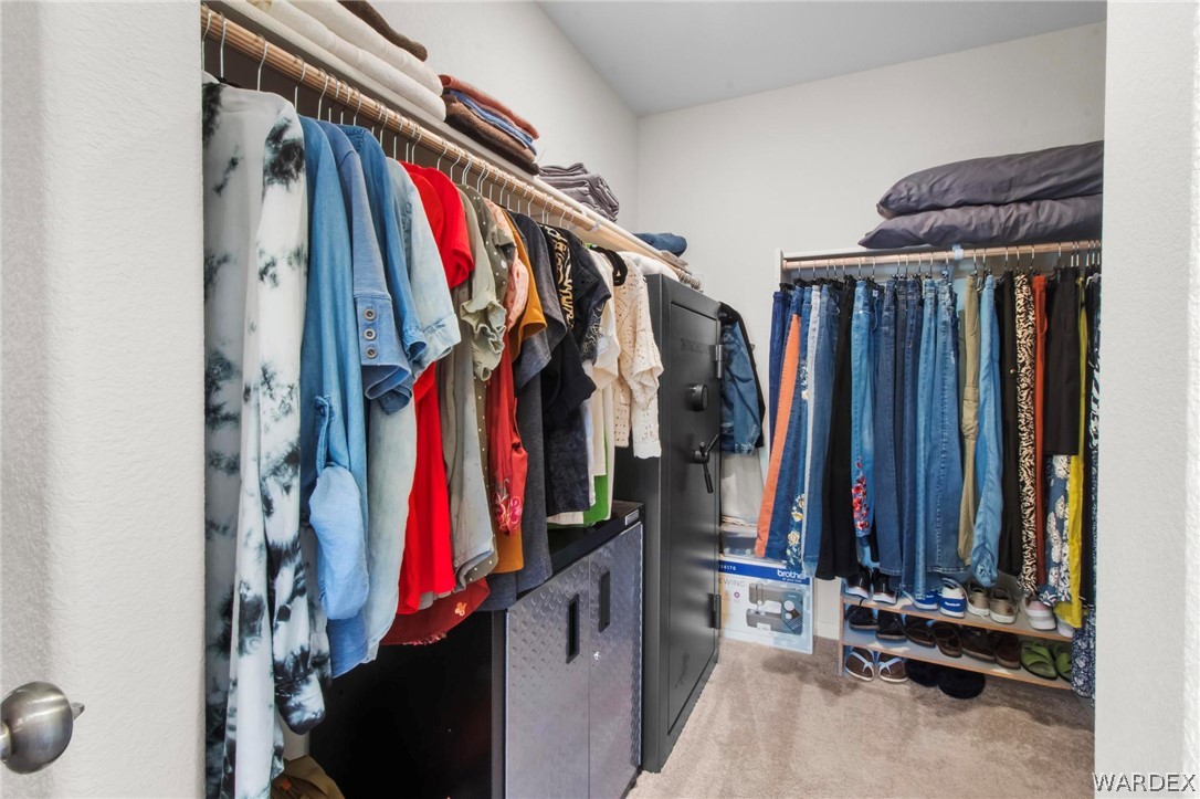 2424 Granite Road Bullhead City, AZ 86442 - Photo 26 of 50 Walk-in closet featuring carpet flooring, built-in shelving, and multiple hanging rods for ample storage