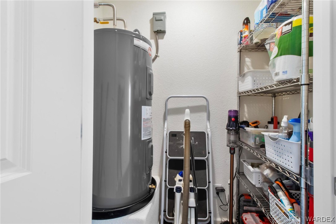 2424 Granite Road Bullhead City, AZ 86442 - Photo 27 of 50 Utility area featuring a water heater, white walls, and built-in metal shelving