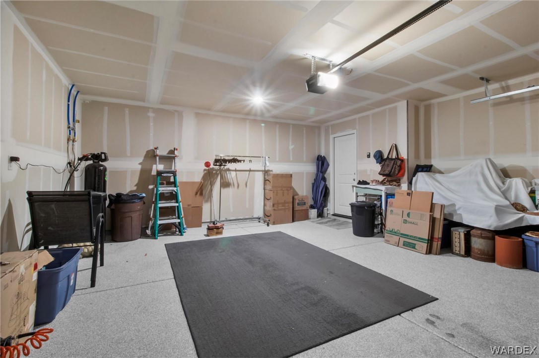 2424 Granite Road Bullhead City, AZ 86442 - Photo 29 of 50 Garage interior featuring an epoxy coated concrete floor, exposed wall studs, and an overhead garage door opener