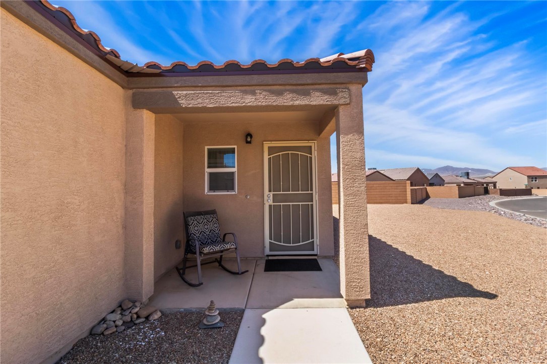2424 Granite Road Bullhead City, AZ 86442 - Photo 3 of 50 Covered entry with stucco exterior and terracotta-style roof tiles