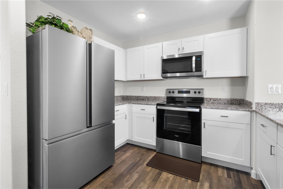 2424 Granite Road Bullhead City, AZ 86442 - Photo 46 of 50 Kitchen featuring stainless steel appliances, white cabinetry, granite-style countertops, wood-finish flooring, and recessed lighting
