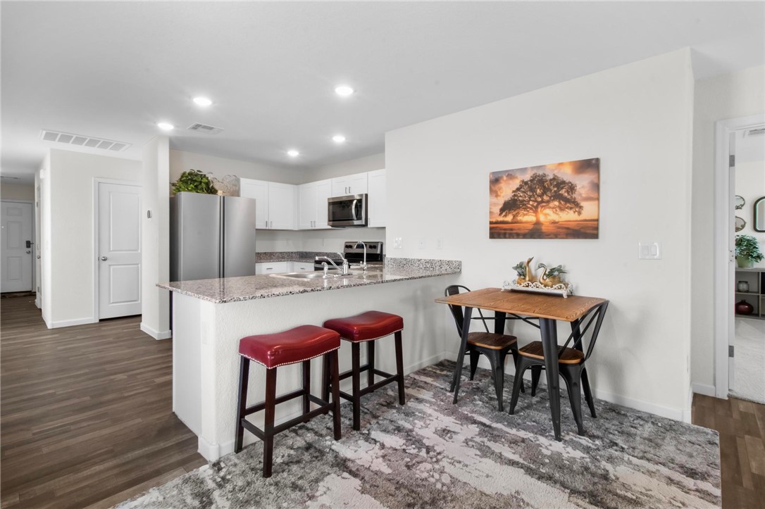 2424 Granite Road Bullhead City, AZ 86442 - Photo 8 of 50 Open-concept kitchen featuring white cabinetry, granite-style countertops, recessed lighting, and stainless steel appliances