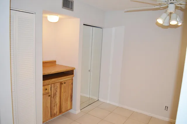 an empty room with a window and a fan