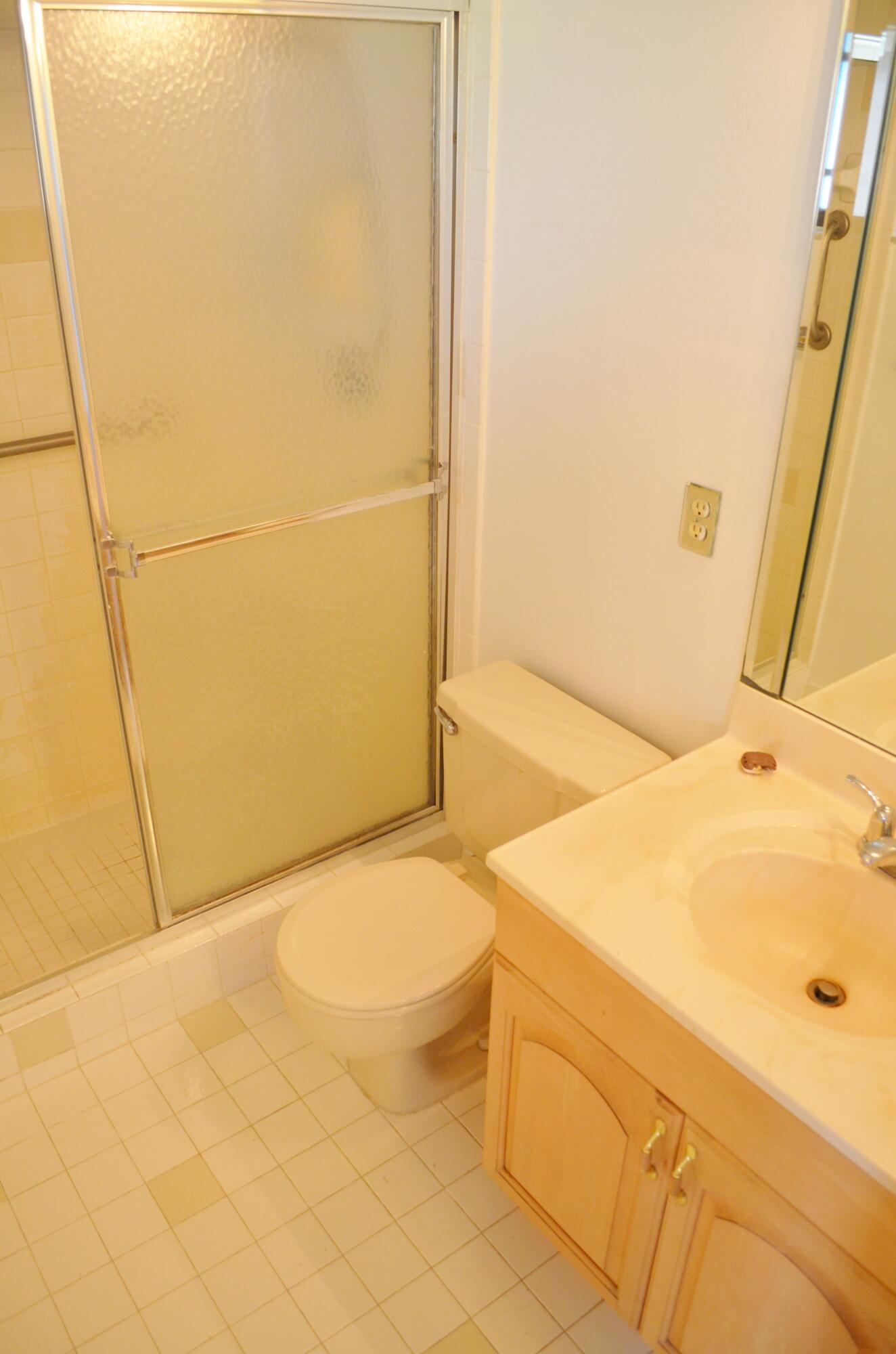 5220 Las Verdes Circle, Unit 211 Delray Beach, FL 33484 - Photo 16 of 57 a bathroom with a sink and a shower