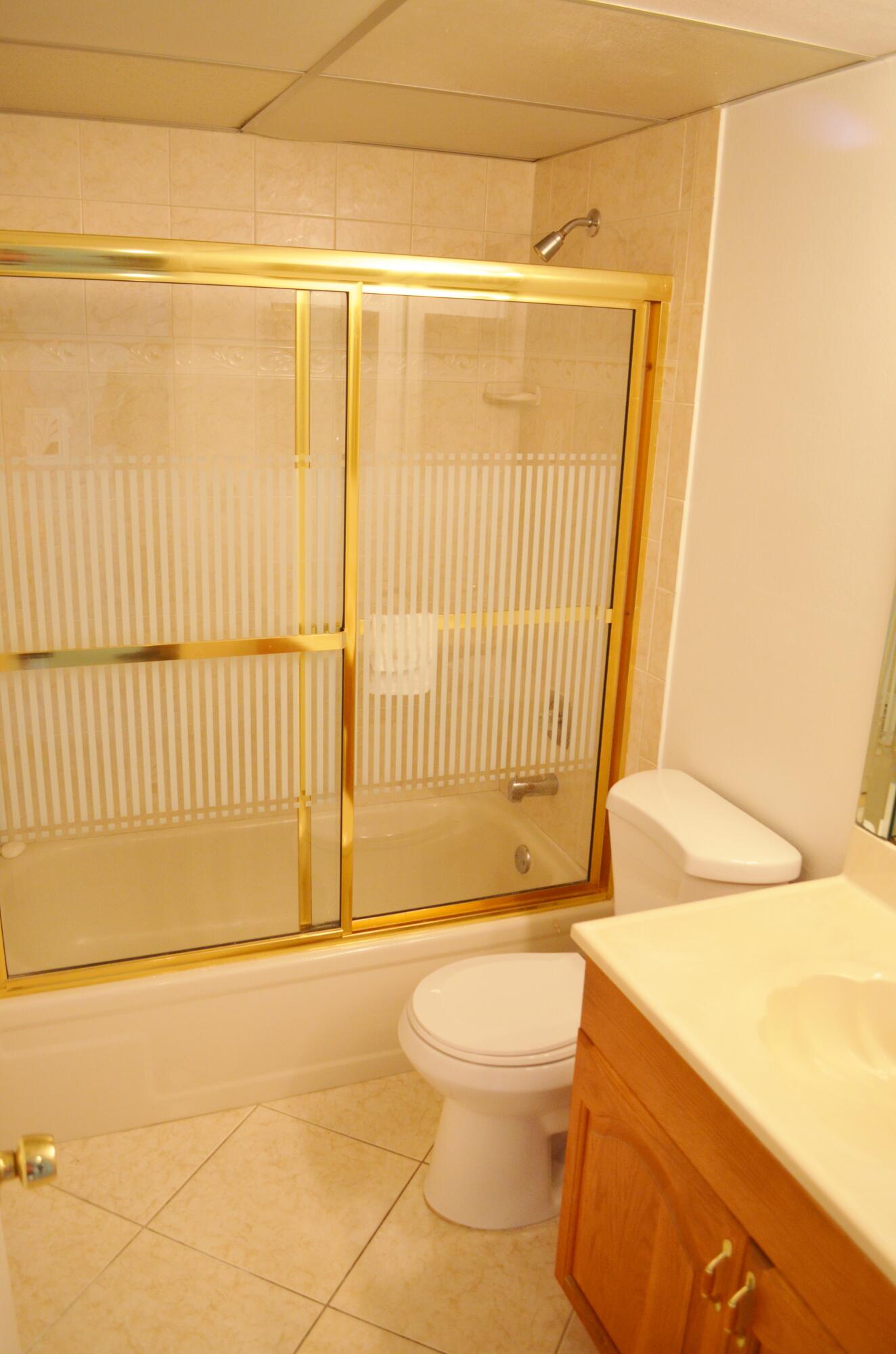 5220 Las Verdes Circle, Unit 211 Delray Beach, FL 33484 - Photo 18 of 57 a bathroom with a toilet and a shower