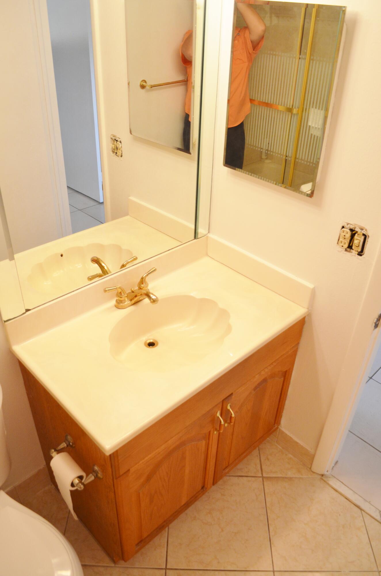 5220 Las Verdes Circle, Unit 211 Delray Beach, FL 33484 - Photo 19 of 57 a bathroom with a tub sink and a mirror