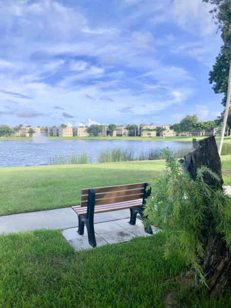 5220 Las Verdes Circle, Unit 211 Delray Beach, FL 33484 - Photo 23 of 57 a view of lake with table and chairs