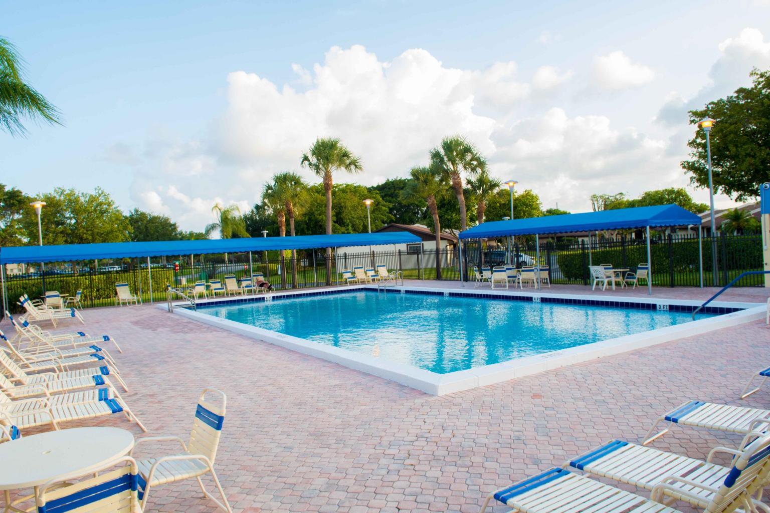 5220 Las Verdes Circle, Unit 211 Delray Beach, FL 33484 - Photo 28 of 57 a view of a swimming pool with a lounge chair