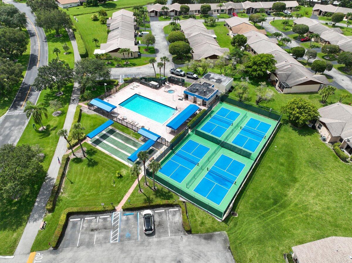 5220 Las Verdes Circle, Unit 211 Delray Beach, FL 33484 - Photo 29 of 57 an aerial view of a tennis ground and a cars park