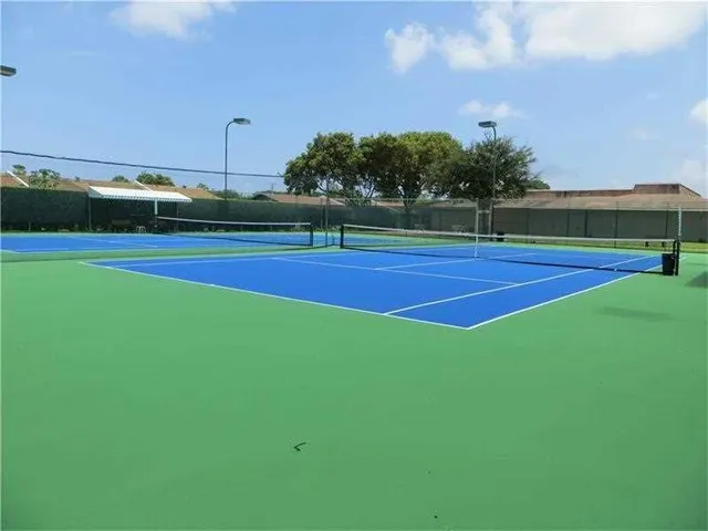 a green field with pool and a table and chairs