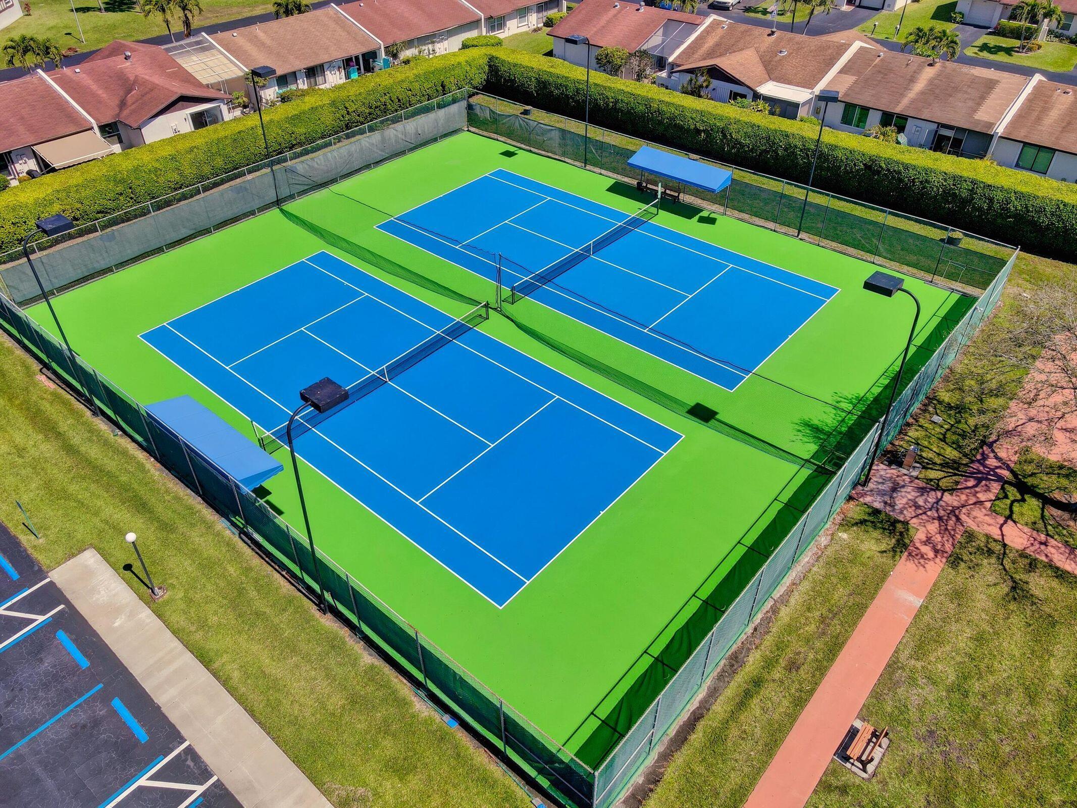 5220 Las Verdes Circle, Unit 211 Delray Beach, FL 33484 - Photo 38 of 57 a green field with pool and a table and chairs