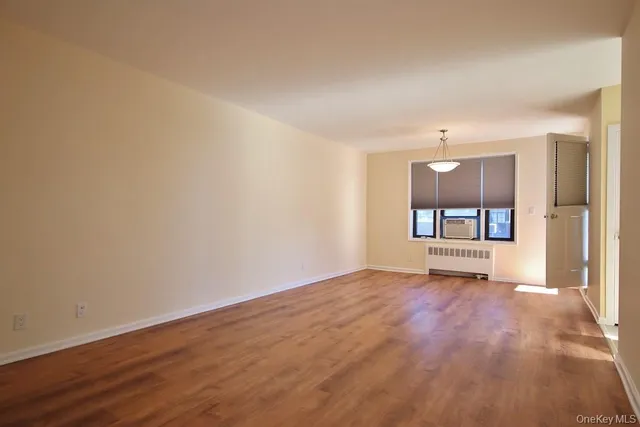 a view of a room with wooden floor and a window