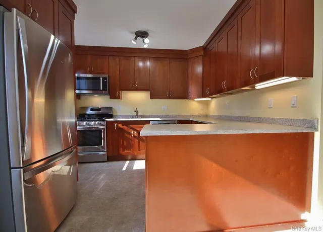 a kitchen with stainless steel appliances granite countertop a refrigerator a stove and a sink