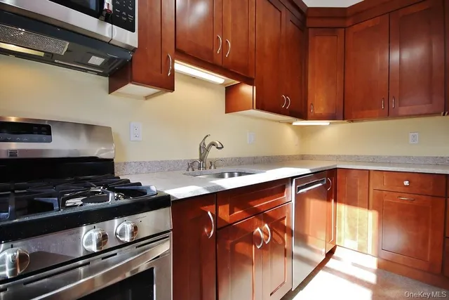 a kitchen with stainless steel appliances granite countertop a sink stove and cabinets