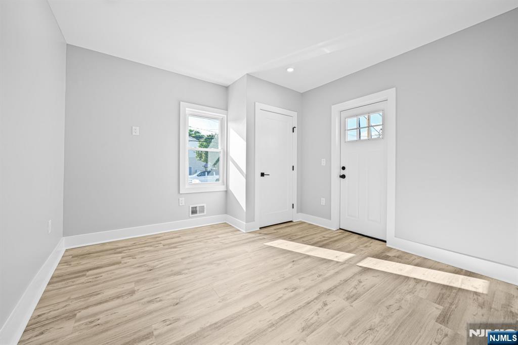 100 Kansas Street, Unit 1 Hackensack, NJ 07601 - Photo 11 of 17 a view of an empty room with wooden floor and a window