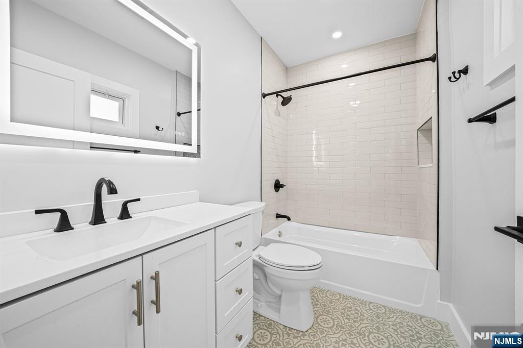 100 Kansas Street, Unit 1 Hackensack, NJ 07601 - Photo 10 of 17 a bathroom with a sink a toilet and shower