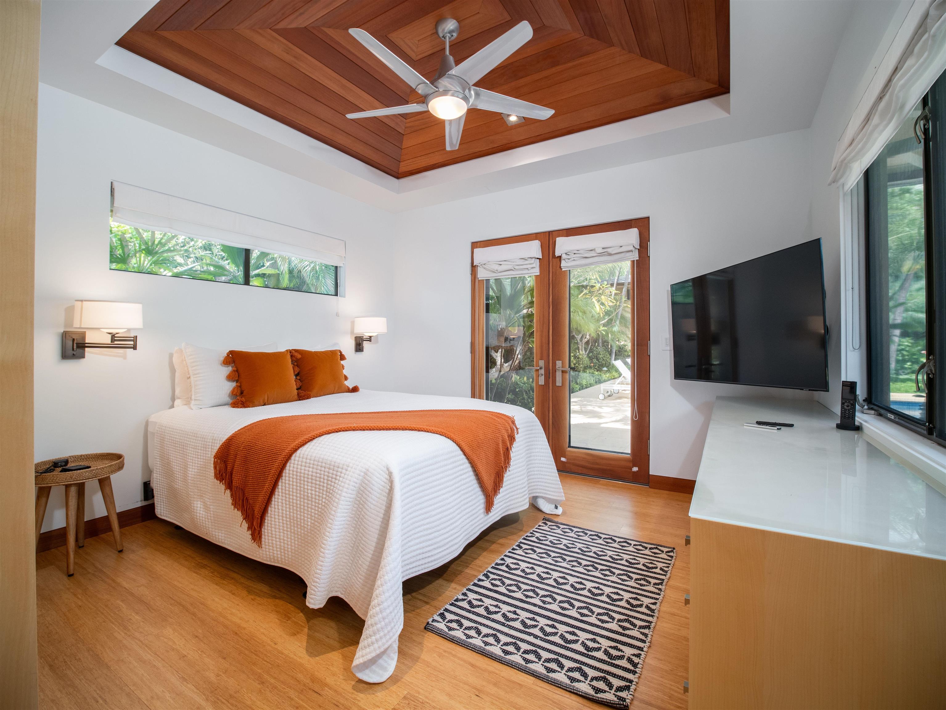 4640-4650 Makena Road Kihei, HI 96753 - Photo 46 of 48 a bed sitting in a bedroom next to a window with a flat screen tv and a couch