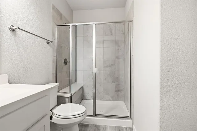 a bathroom with a shower a toilet and a sink