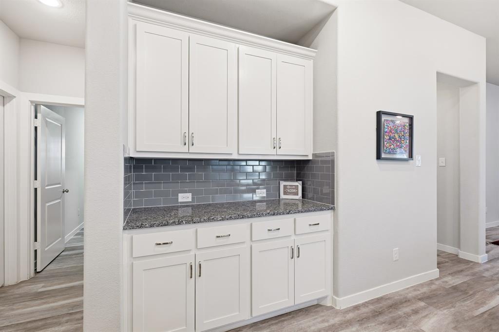 3921 Madison Lane Denton, TX 76208 - Photo 29 of 37 a kitchen with granite countertop white cabinets and stainless steel appliances