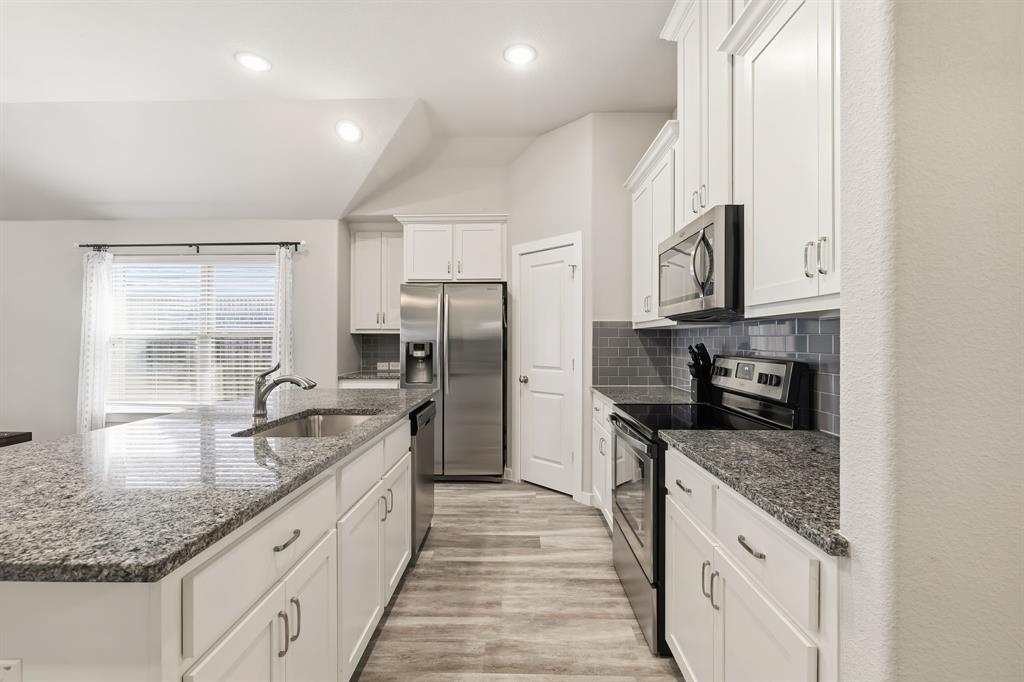 3921 Madison Lane Denton, TX 76208 - Photo 5 of 37 a kitchen with granite countertop lots of counter top space and stainless steel appliances