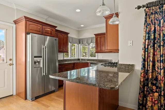 a kitchen with stainless steel appliances granite countertop a refrigerator a sink and a stove