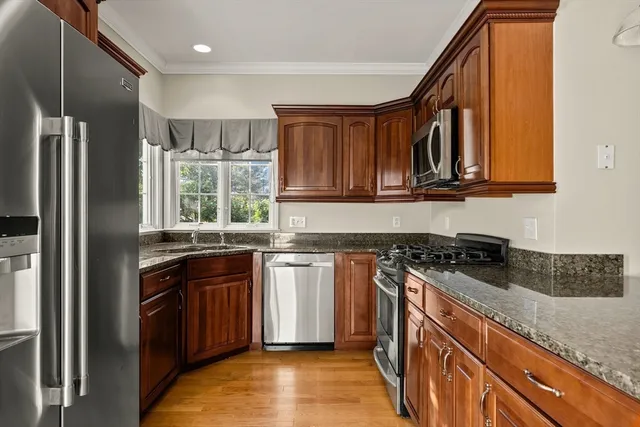 a kitchen with granite countertop a sink stove and refrigerator