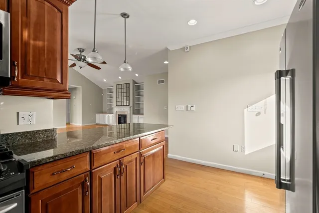 a kitchen with stainless steel appliances granite countertop a sink a refrigerator and a granite counter tops