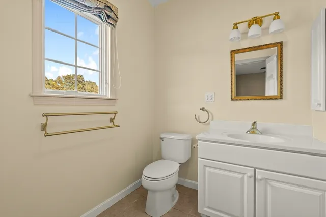 a bathroom with a toilet sink vanity and mirror