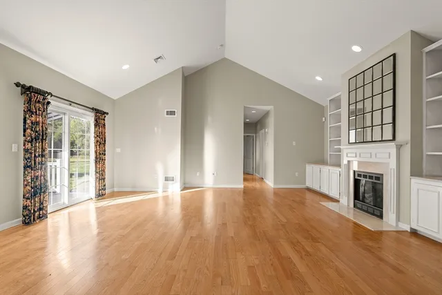 a view of an empty room with a fireplace and a window